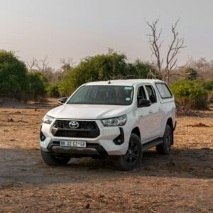 White Toyota Hilux pickup parked in a dry landscape